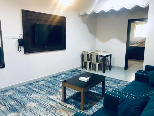 uma sala de estar com um sofá, uma mesa e uma televisão em افضل واحد للوحدات السكنية المخدومة - بست ون em Ad Dawādimī