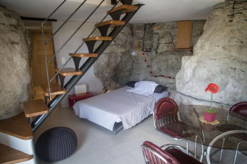 LanasにあるDomaine Les Princes, Logis Troglodyteの洞窟内のベッドルーム(ベッド1台、階段付)