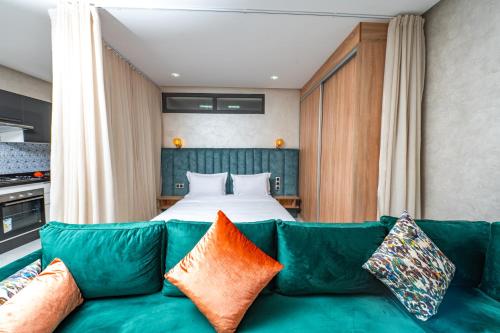 卡薩布蘭卡的住宿－Maarif Elite Suites，客厅配有绿色沙发和床。