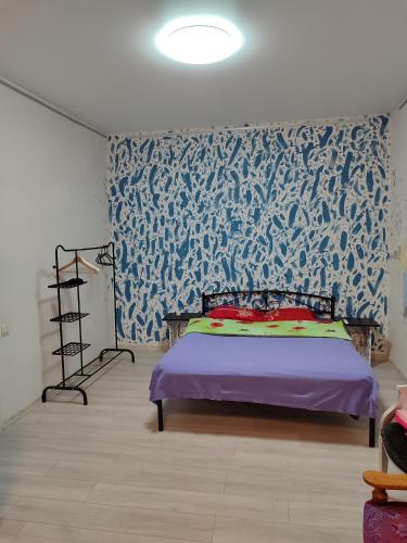 a bedroom with a bed with a blue and white wallpaper at Квартира целиком Киев Подол метро Контрактовая площадь in Kyiv