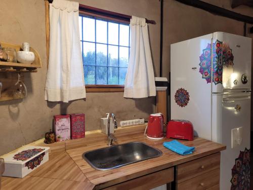 a kitchen with a sink and a refrigerator at Casa Sueños Tandil in Tandil