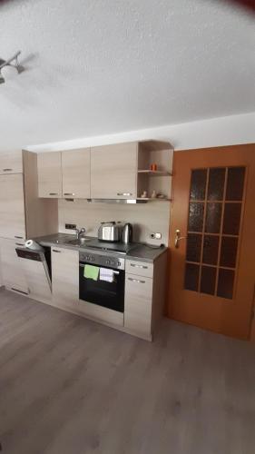 a kitchen with white cabinets and a stove top oven at Ferienwohnung am Querweg in Bockau