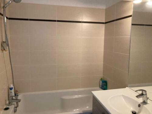 a bathroom with a tub and a sink and a bath tub at Maison proche de Versailles JO2024 in Saint-Cyr-lʼÉcole