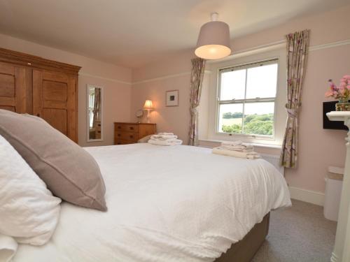 a bedroom with a large white bed and a window at 3 Bed in Bothenhampton DC160 in Bridport
