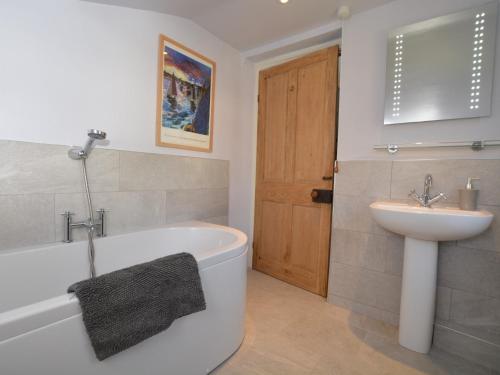 a bathroom with a sink and a tub and a toilet at 3 Bed in Bothenhampton DC160 in Bridport