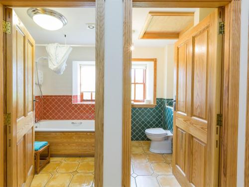 a bathroom with a toilet and a bath tub at 2 bed property in Cairnbaan CA113 in Cairnbaan