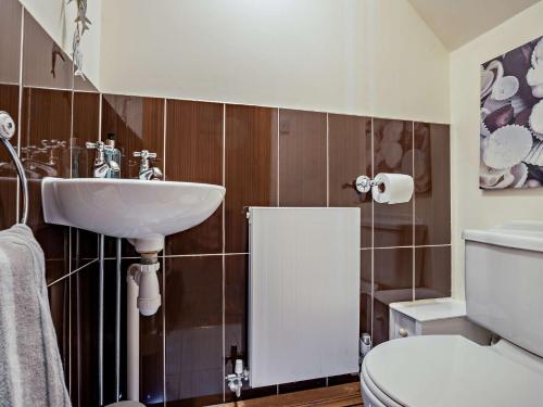 a bathroom with a sink and a toilet at 3 Bed in Heacham 65596 in Heacham