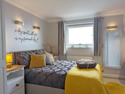 a bedroom with a bed and a window and a mirror at The Gables in Bognor Regis
