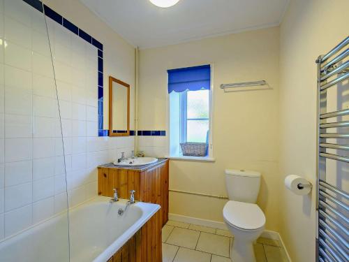 a bathroom with a tub and a toilet and a sink at 2 bed in Strontian CA046 in Scotstown