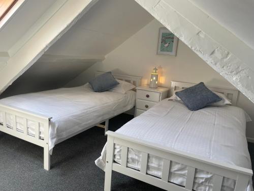 zwei Betten in einem Zimmer mit Dachboden in der Unterkunft Drift Cottage - Fisherman's Cottage Brixham harbour in Brixham