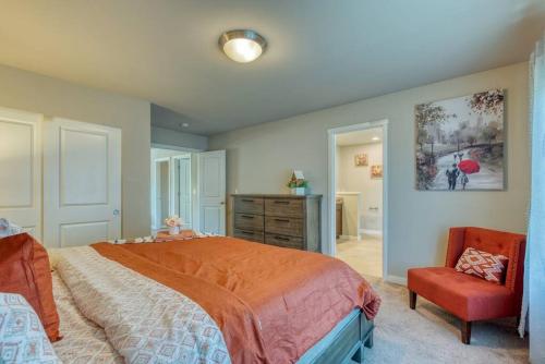 1 dormitorio con cama, silla y vestidor en xx Quieter Villa, en Everett