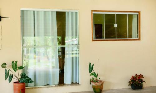 a window with a blue curtain and some plants at Rancho das Estrelas in Carolina