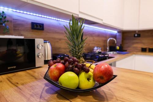 a bowl of fruit on a wooden table in a kitchen at Grgic Apartments - Lux APT2 - Free Parking in Zagreb
