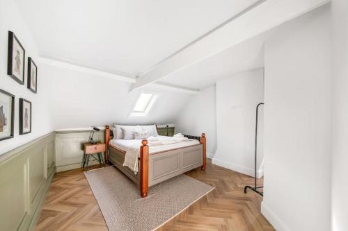 een slaapkamer met een bed in een kamer met witte muren bij Aldwark Attic is 4 min to The Shambles with Free Wifi in York