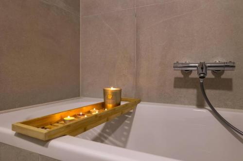 a bath tub with a tray with candles on it at Grgic Apartments - Lux APT2 in Zagreb