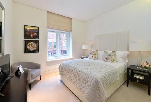 a bedroom with a bed and a desk and a window at PARK LANE LARGE LUXURY SLEEPS 6 in London