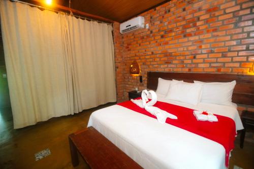 a bedroom with a large bed with red and white towels at Rancho das Estrelas in Carolina
