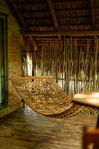 a rattan hammock in a room with a brick wall at Rancho das Estrelas in Carolina
