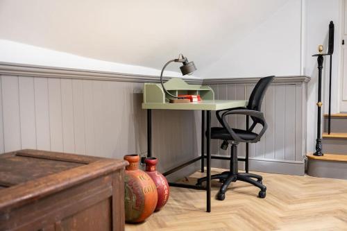 a desk and a chair in a room with vases at Aldwark Attic is 4 min to The Shambles with Free Wifi in York