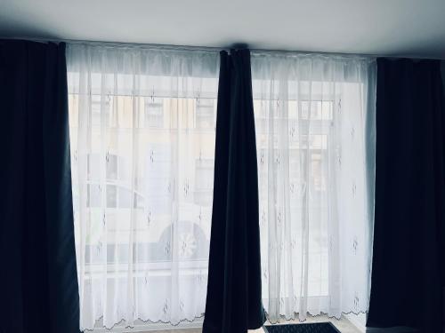 a window with black and white curtains in a room at Apartment in Stadtzentrum Oelsnitz in Oelsnitz