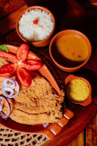 a plate of food with rice and vegetables and sauce at Rancho das Estrelas in Carolina