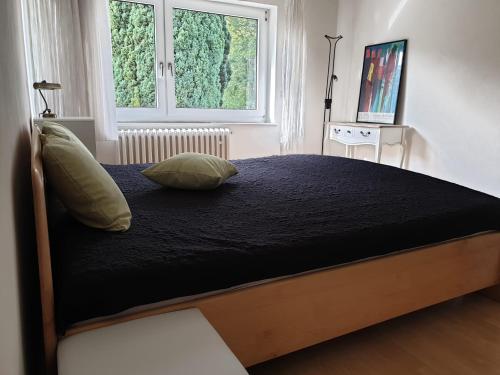 ein Bett mit zwei Kissen darauf in einem Schlafzimmer in der Unterkunft Ferienhaus in Wilhelmshöhe in Kassel