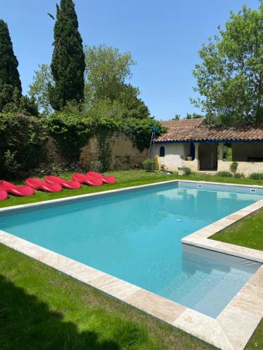 - une piscine avec des chaises rouges dans la cour dans l'établissement B&B Château de Fajac la Selve, à Pech-Luna