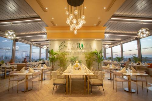 a rendering of a restaurant with tables and chairs at La Terrazza Hotel in Mağusa