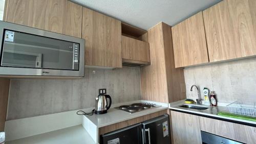 uma cozinha com um micro-ondas e um fogão forno superior em Depto nuevo en republica cercano al movistar arena em Santiago