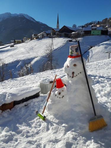 a snowman with a broom in the snow at Neuner Charlotte Preise inclusive Sommercard in Wenns