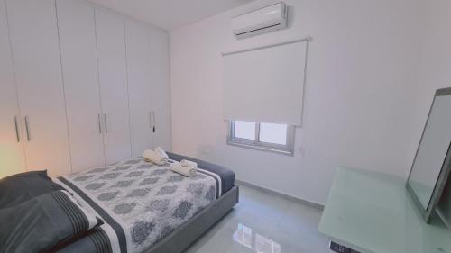 Kleines weißes Zimmer mit einem Bett und einem Fenster in der Unterkunft STAY Elysian House in Limassol