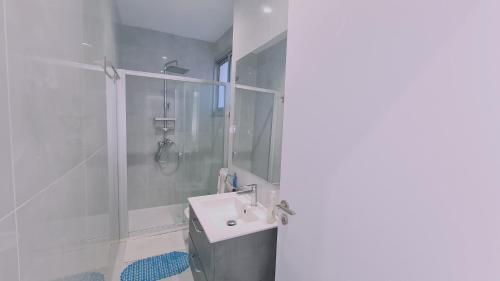 ein weißes Bad mit einer Dusche und einem Waschbecken in der Unterkunft STAY Elysian House in Limassol