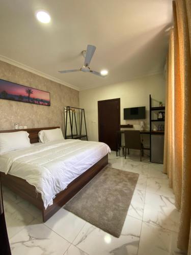 a bedroom with a bed and a desk at Post Ridge Hotel in Accra