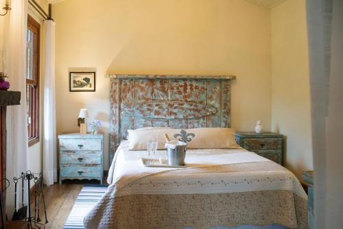 a bedroom with a bed with a blue headboard at Pousada Terra Crua in Visconde De Maua