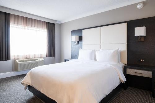 a large white bed in a hotel room with a window at Crowne Plaza Hotel Moncton Downtown, an IHG Hotel in Moncton