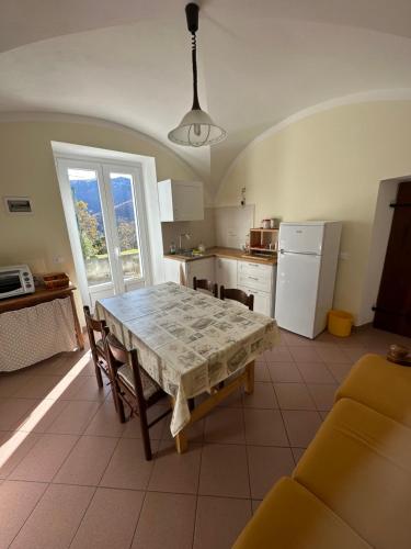 a kitchen with a table and a kitchen with a table and chairs at Casa Iolanda in Bognanco