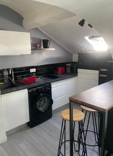 une cuisine avec une machine à laver et une table dans l'établissement Studio Cannes banane, à Cannes