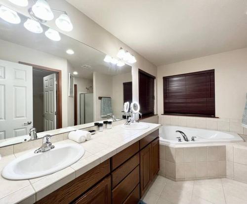 Un baño con dos lavabos y un espejo grande. en EV2-GRACE VILLA-Many BRs and loft, en Everett
