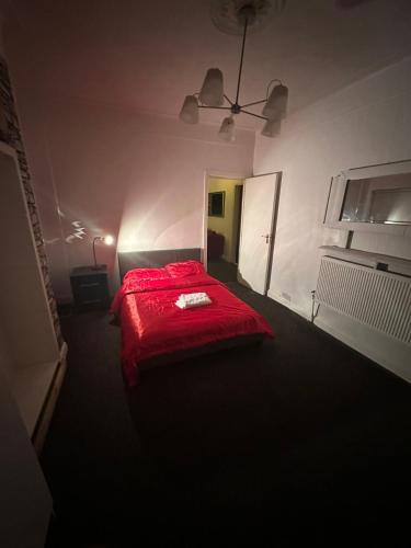 a bedroom with a red bed with a red blanket at Spacious 1 bedroom en-suite, kitchen and garden space in Ilford