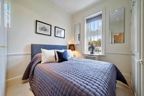 a bedroom with a bed and a window at Finest Retreats - Elm Tree in London
