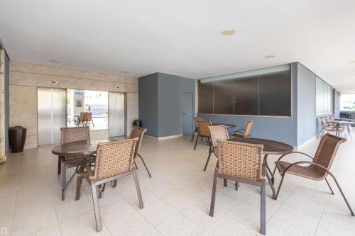 a dining room with tables and chairs in a room at Nobile Suítes Uberlândia in Uberlândia