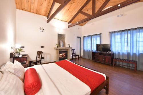 1 dormitorio con 1 cama grande y chimenea en The Hearth en Kodaikānāl