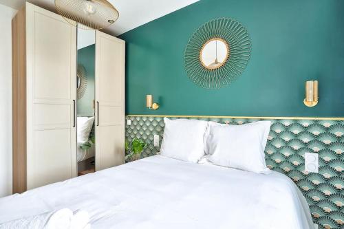 Dormitorio azul con cama y espejo en Splendid apartment for 2 persons, en Aubervilliers