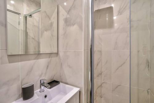 a white bathroom with a shower and a sink at Splendid apartment for 2 persons in Aubervilliers