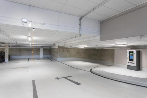 an empty parking garage with a large room with white floors at Hotel einsmehr in Augsburg
