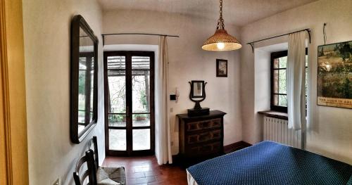 a room with a bed and a mirror and windows at Agriturismo Casa Greppo in San Venanzo