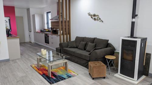 - un salon avec un canapé et une table en verre dans l'établissement Domaine de la Griffe - Appartement moderne à la montagne, à La Roche-sur-Foron
