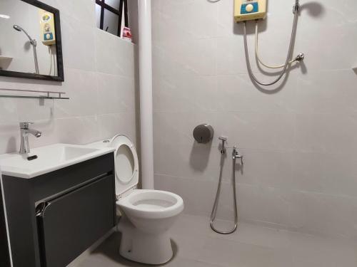 a bathroom with a toilet and a sink and a shower at SS Ipoh Comfort Homestay - Taman Bertuah in Ipoh