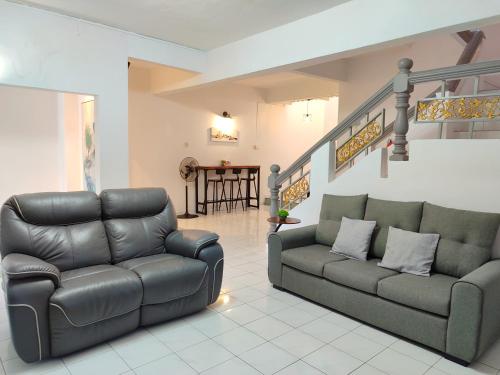 a living room with a couch and a chair at SS Ipoh Comfort Homestay - Taman Bertuah in Ipoh