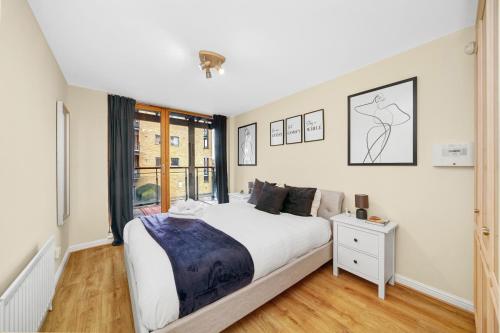 a bedroom with a large bed and a window at 2 Bedroom Riverside Apartment near Canary Wharf! in London